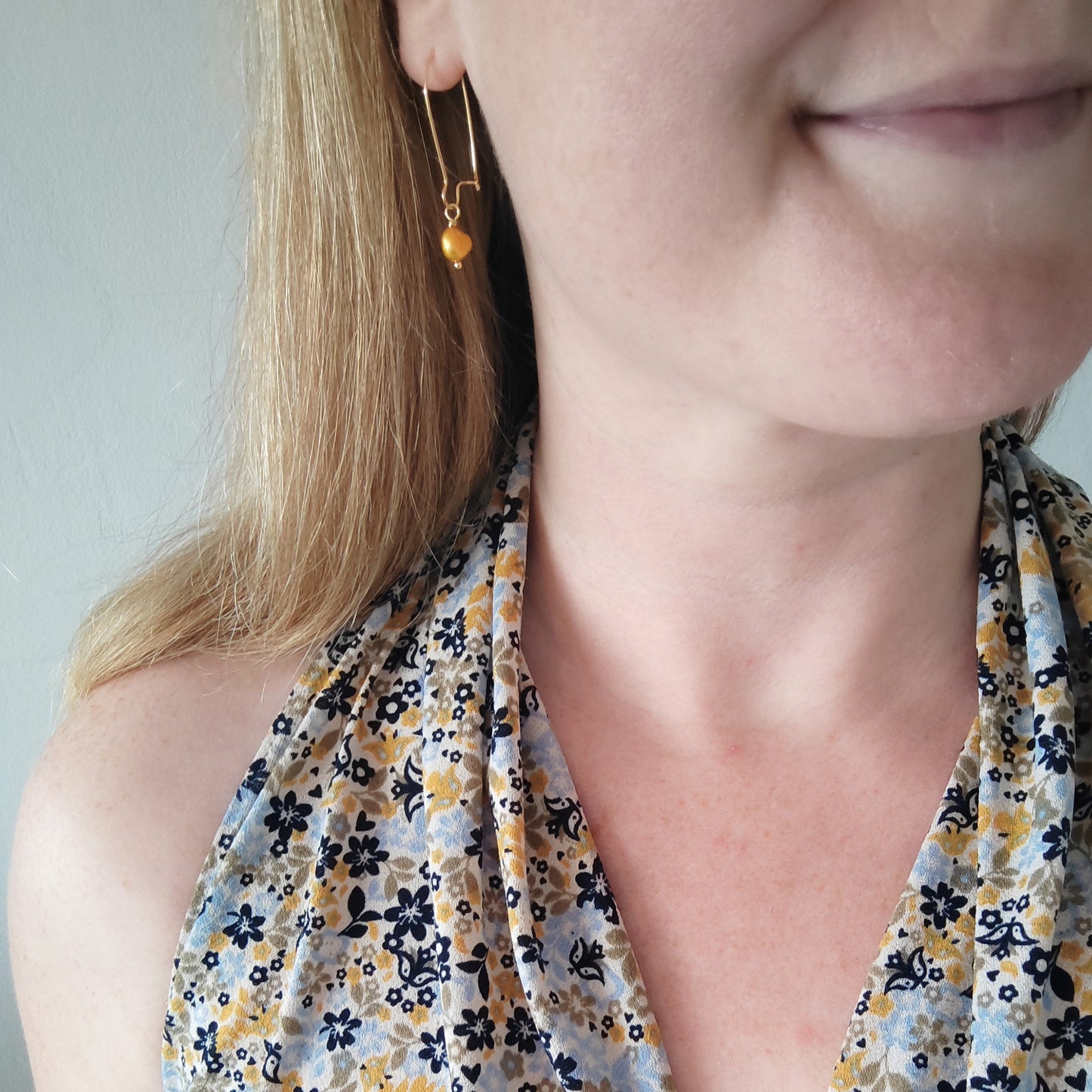 Woman wearing baroque freshwater pearl drop earrings.