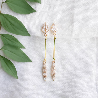 Art deco gold bar earrings on a white cloth.