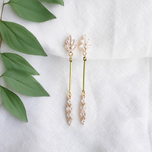 Art deco gold bar earrings on a white cloth.