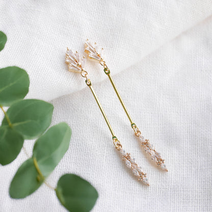 Art deco gold bar earrings on a white cloth.
