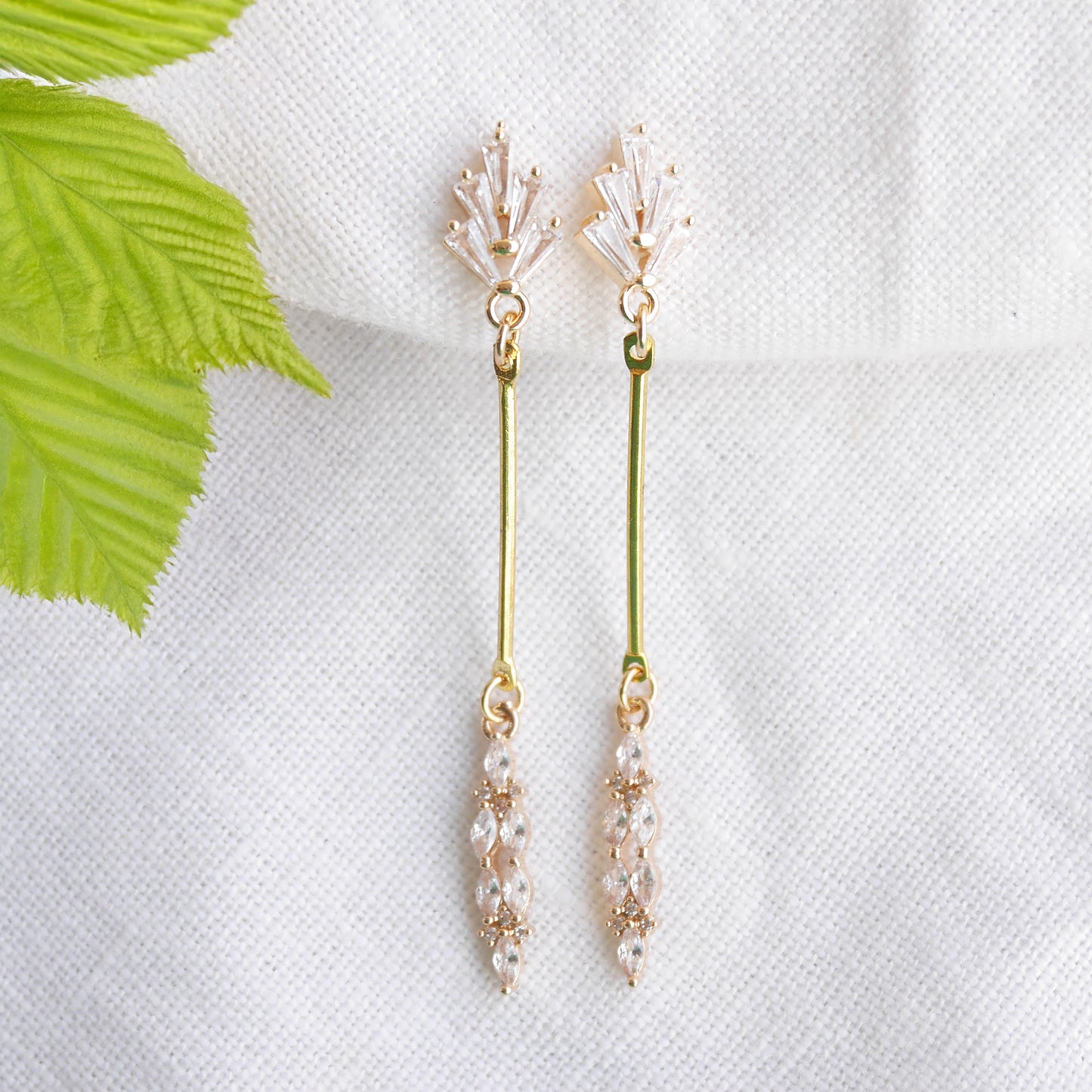 Art deco gold bar earrings on a white cloth.