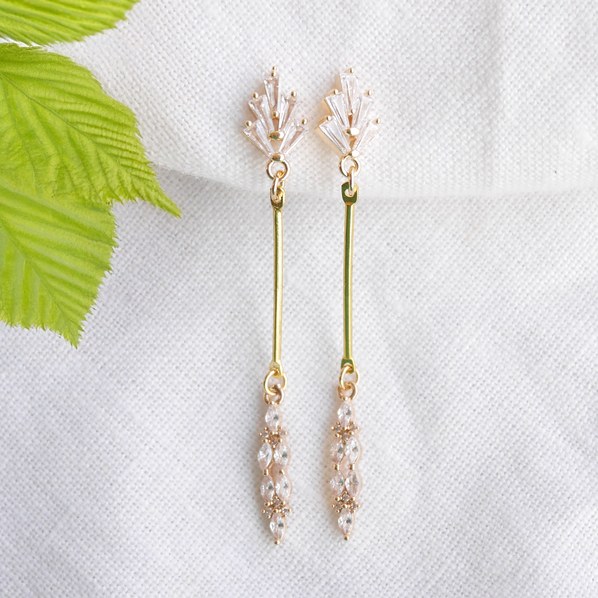 Art deco gold bar earrings on a white cloth.