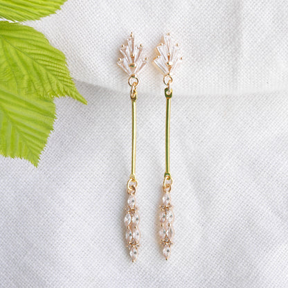 Art deco gold bar earrings on a white cloth.