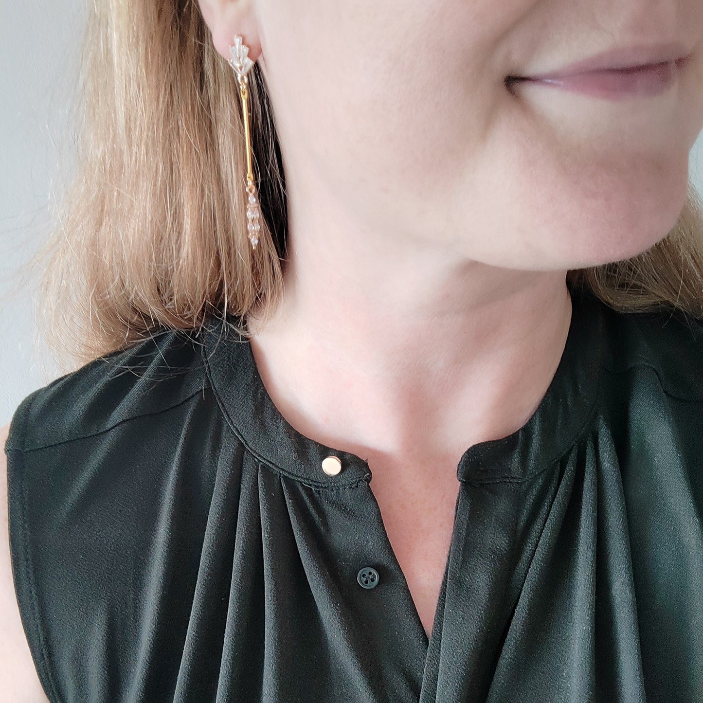 Woman wearing art deco gold bar earrings.