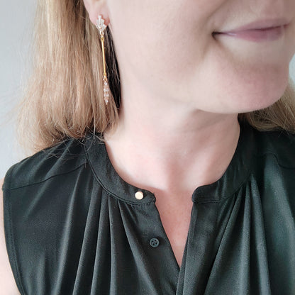 Woman wearing art deco gold bar earrings.