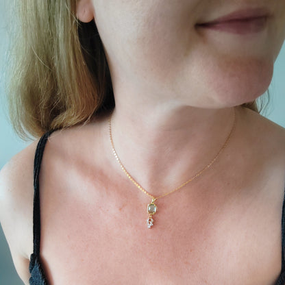 Woman wearing art deco style lake blue glass gold necklace.