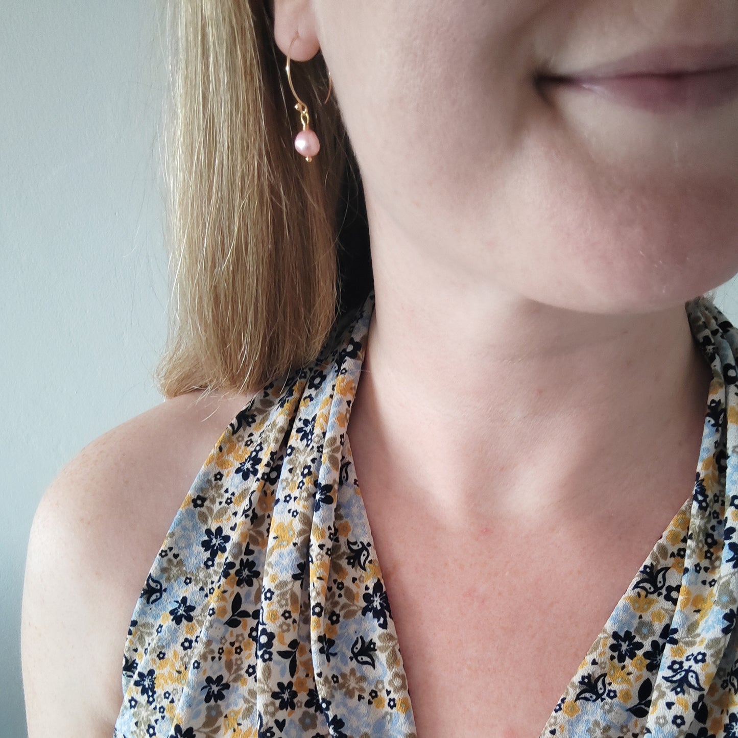 Woman wearing baroque freshwater pearl drop earrings.