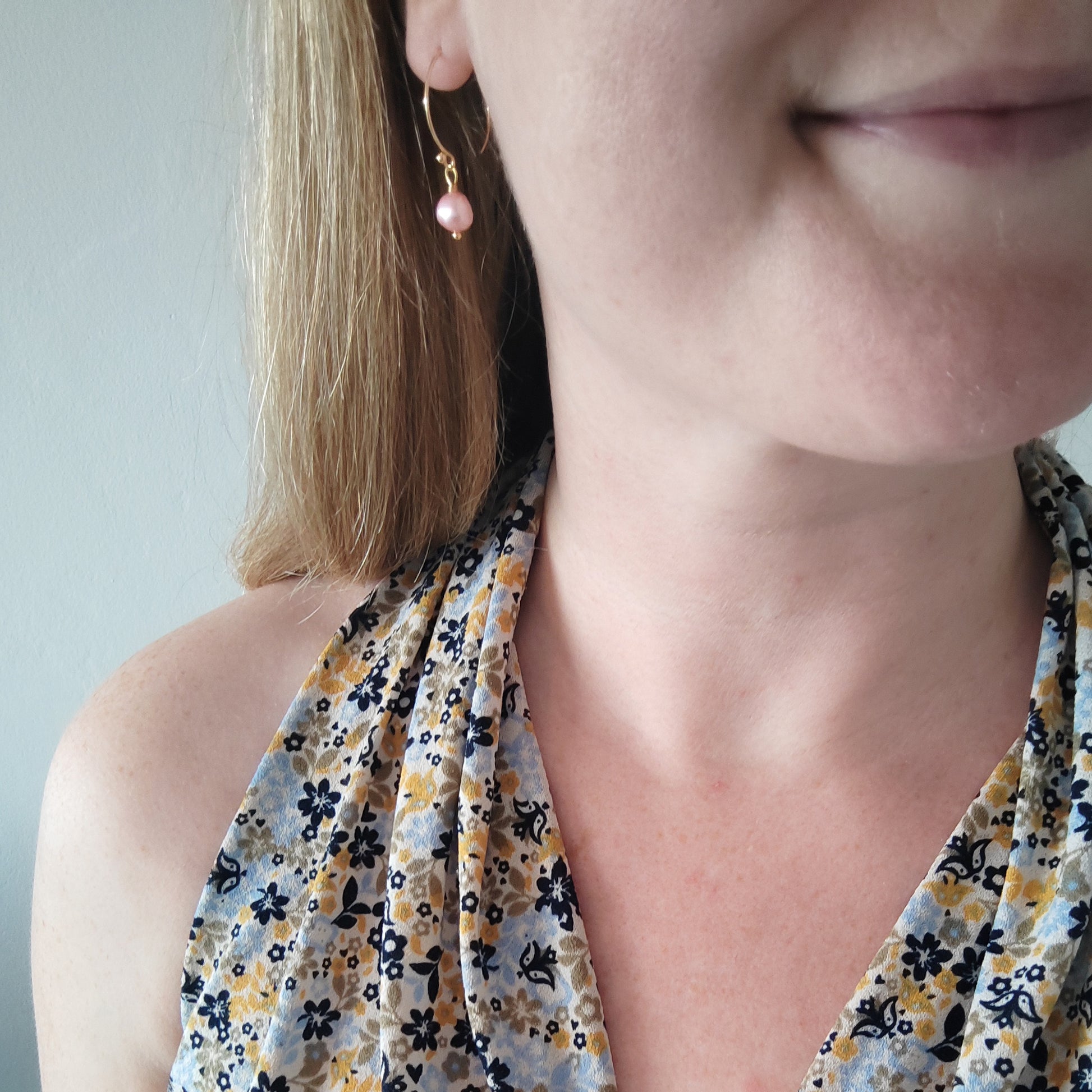 Woman wearing baroque freshwater pearl drop earrings.