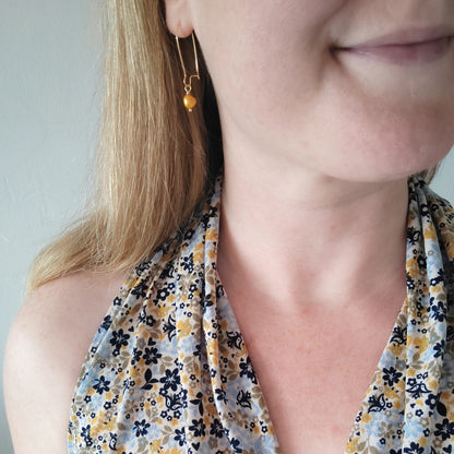 Woman wearing baroque freshwater pearl drop earrings.