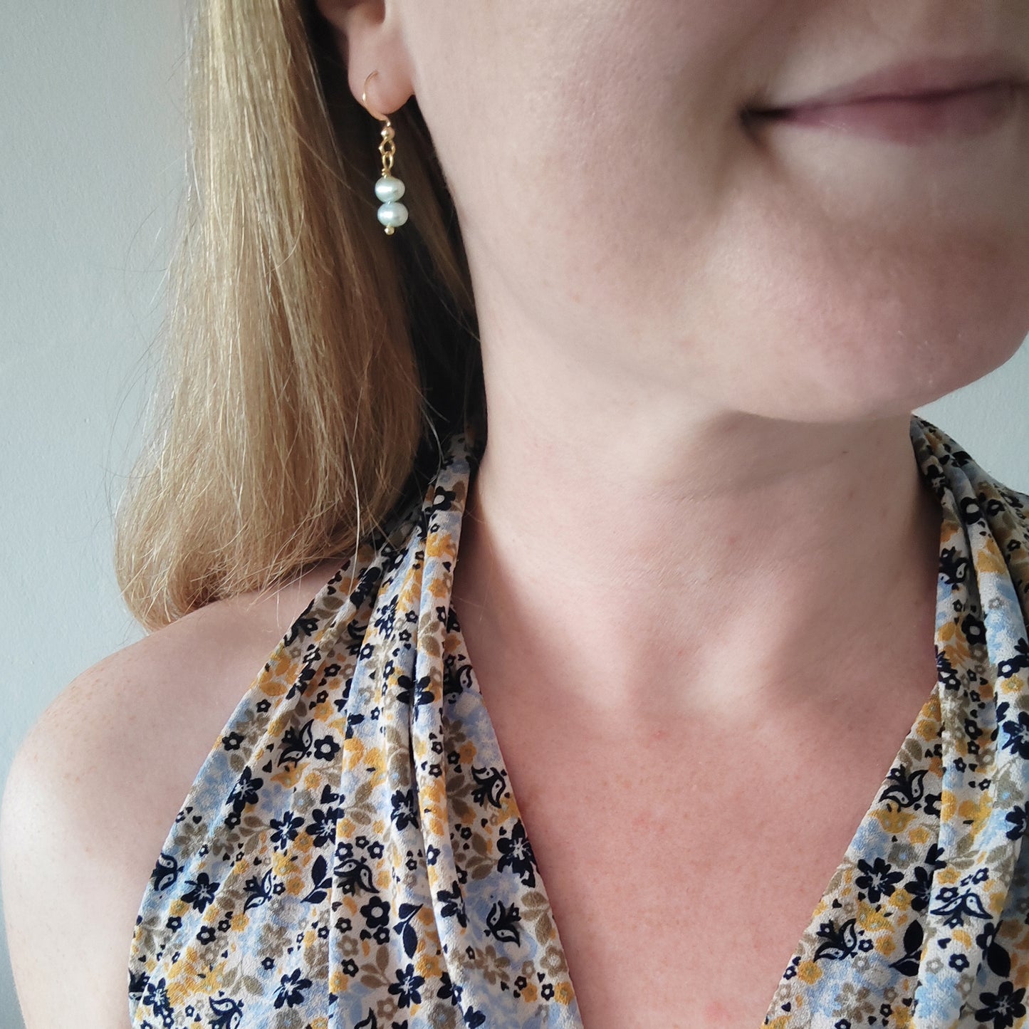 Woman wearing baroque freshwater pearl drop earrings.