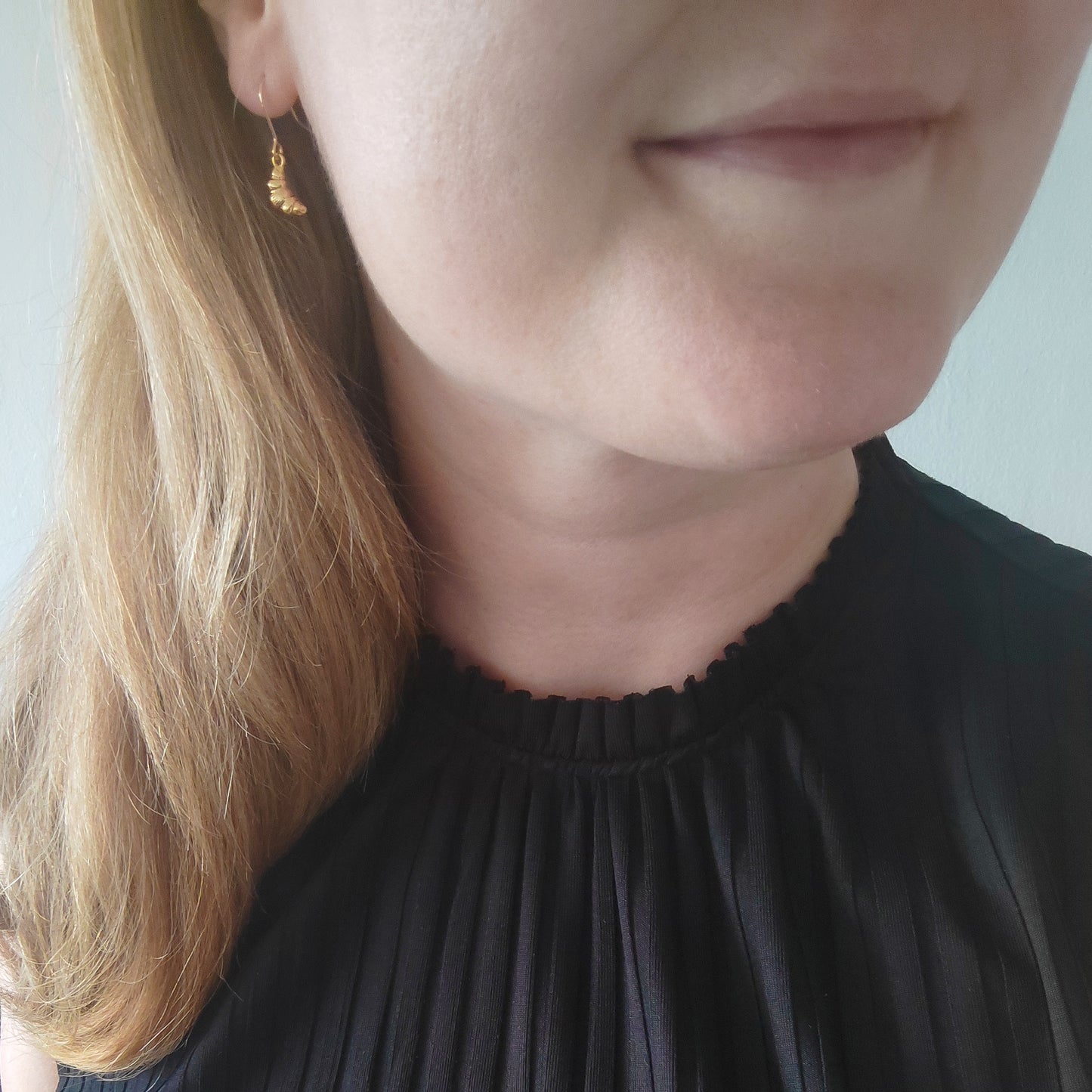 Woman wearing croissant earrings.