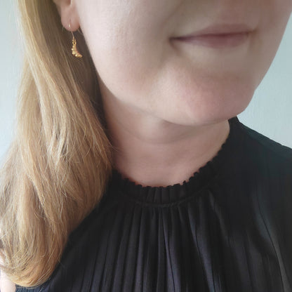 Woman wearing croissant earrings.