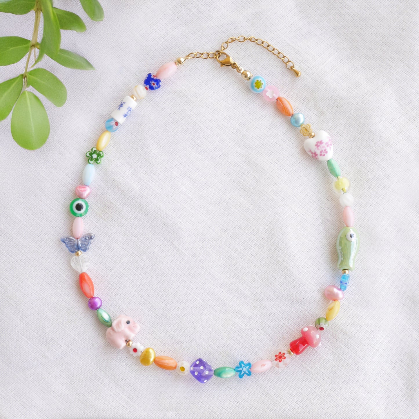Colorful mixed beads necklace on a white cloth.