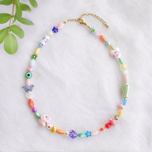 Colorful mixed beads necklace on a white cloth.