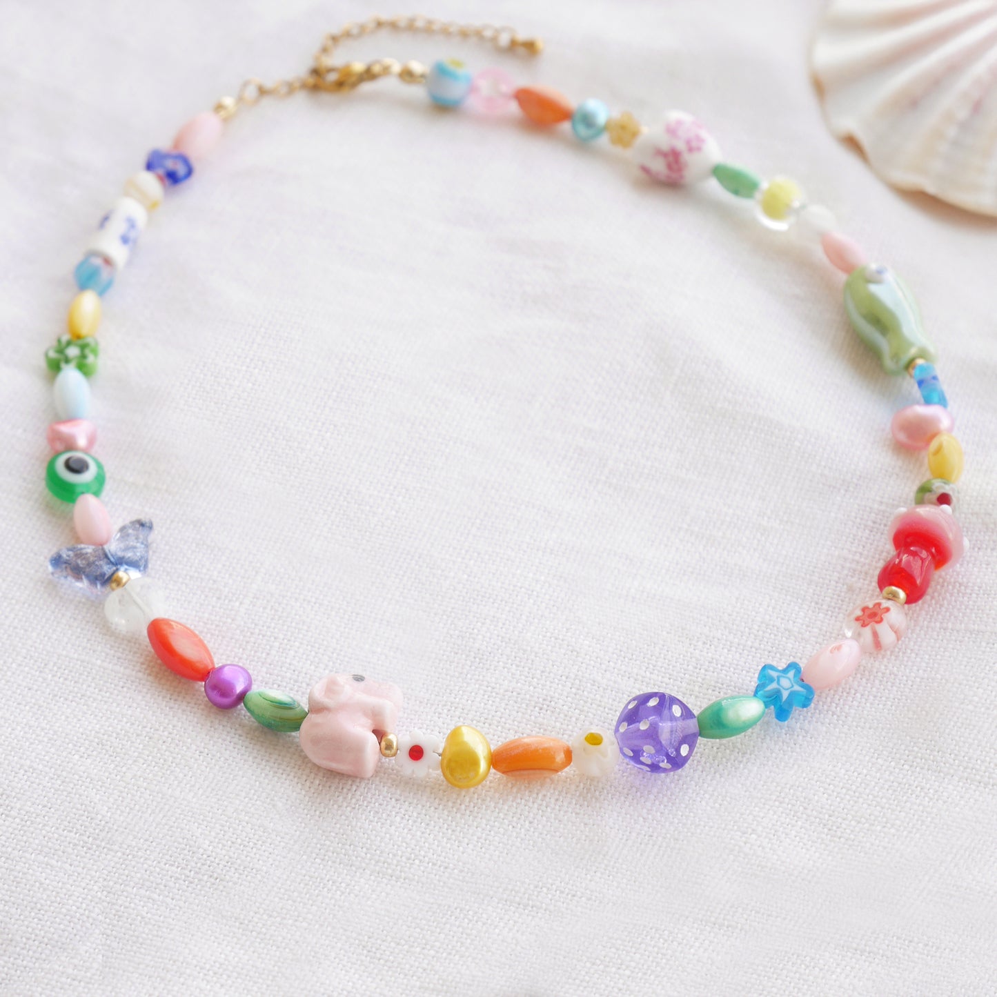 Colorful mixed beads necklace on a white cloth.