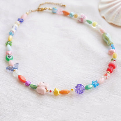 Colorful mixed beads necklace on a white cloth.