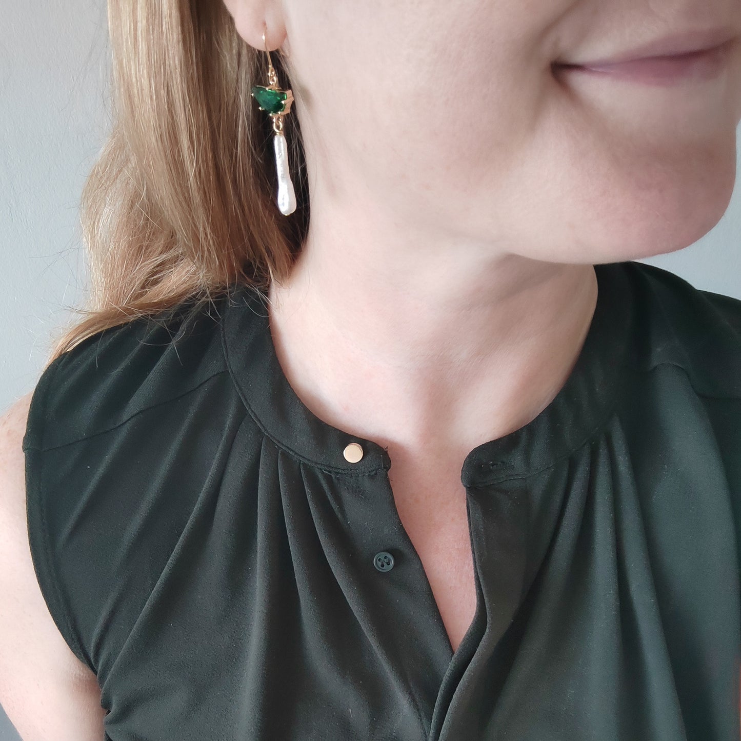 Woman wearing green biwa pearl earrings.