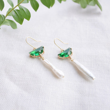 Green biwa pearl earrings on a white cloth.