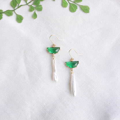 Green biwa pearl earrings on a white cloth.