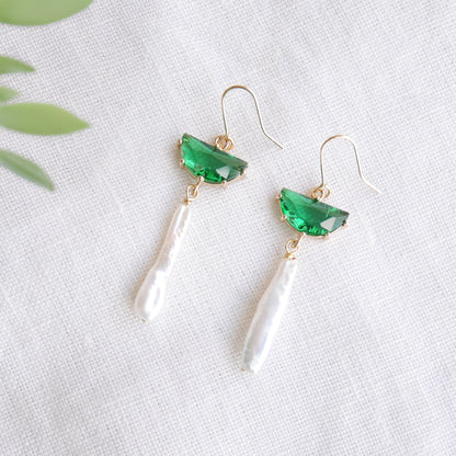 Green biwa pearl earrings on a white cloth.
