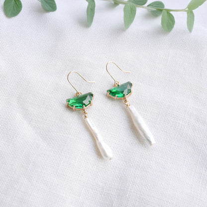 Green biwa pearl earrings on a white cloth.