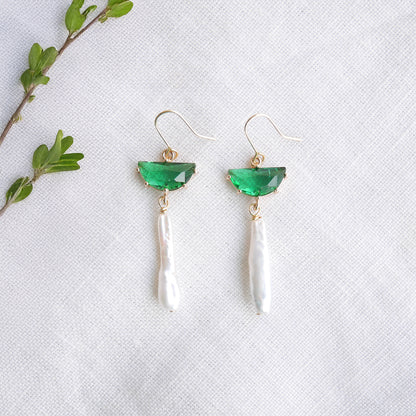 Green biwa pearl earrings on a white cloth.