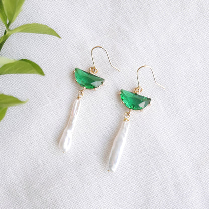Green biwa pearl earrings on a white cloth.