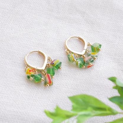 Green glass chip hoop earrings on a white cloth.