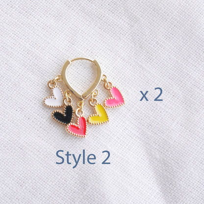 Colorful heart cluster hoop earrings on a white cloth.