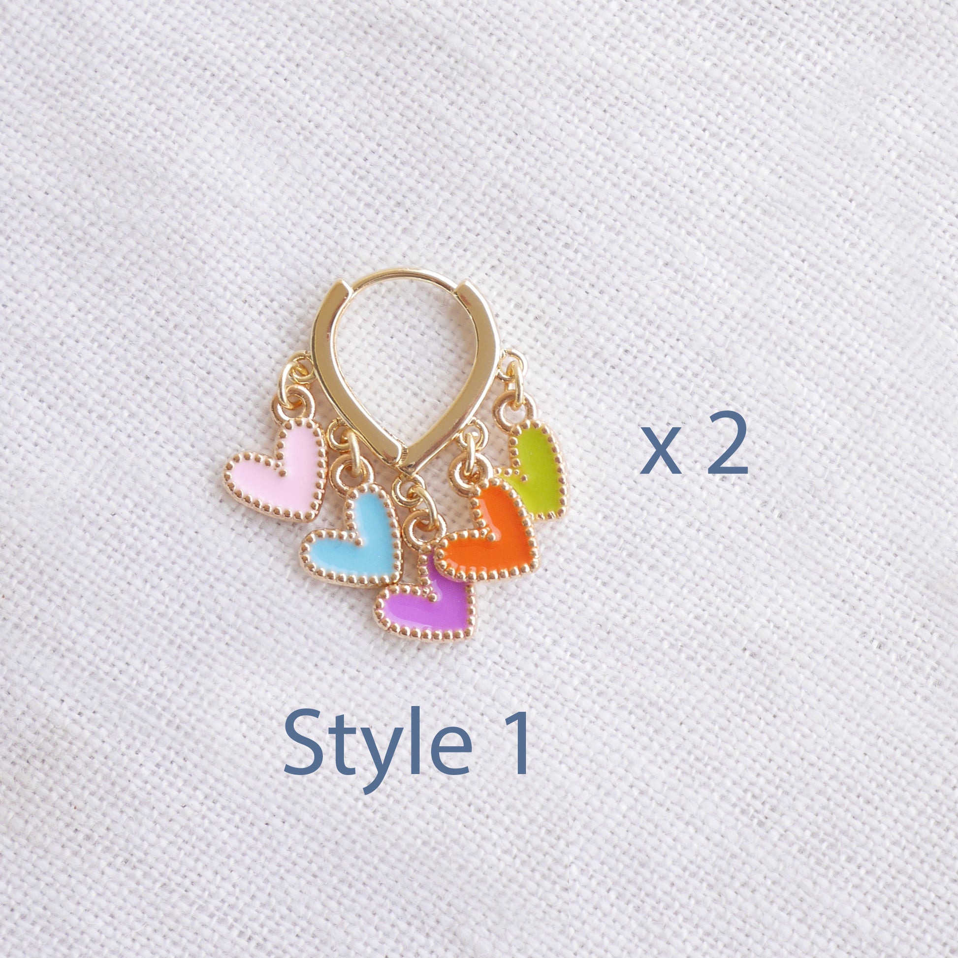 Colorful heart cluster hoop earrings on a white cloth.