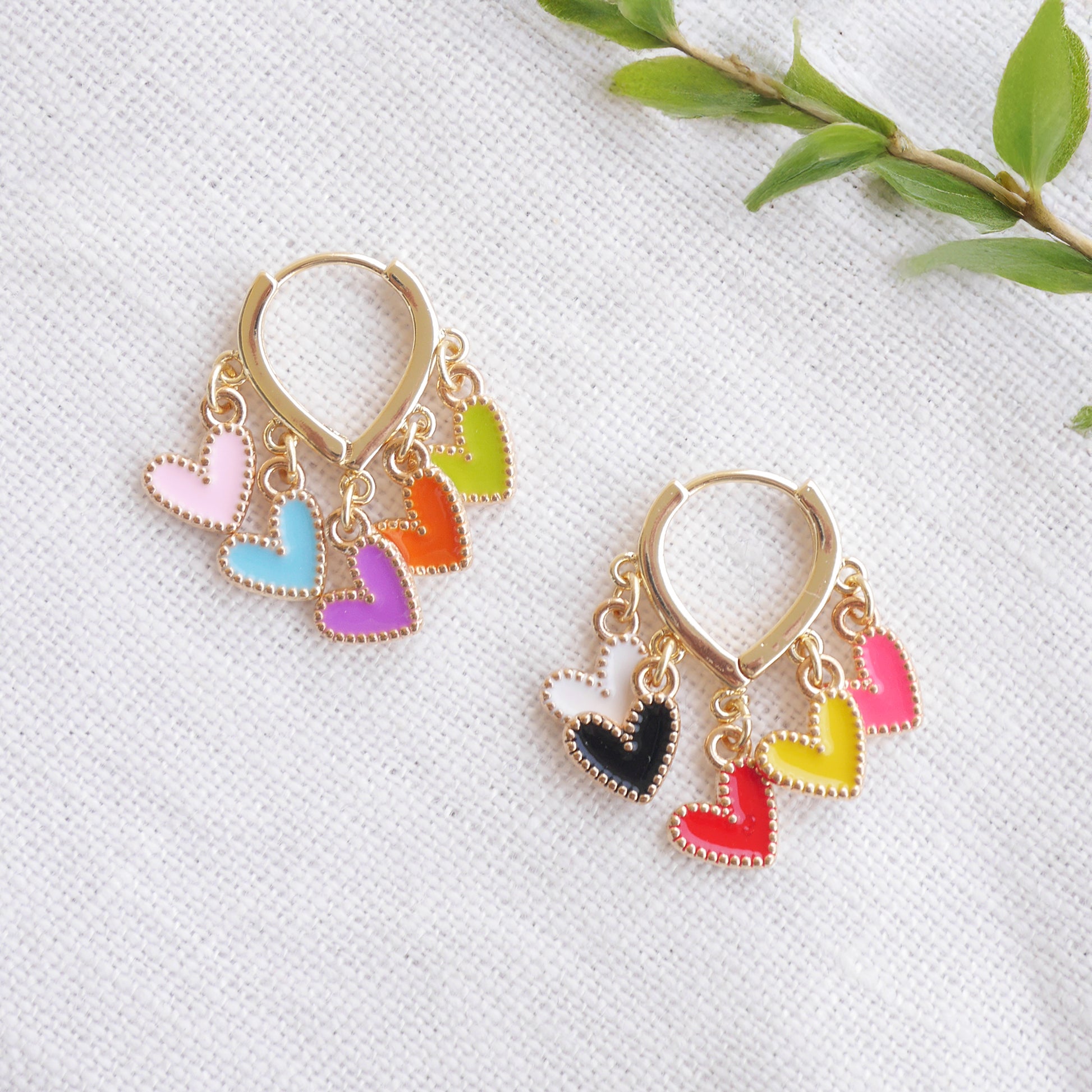 Colorful heart cluster hoop earrings on a white cloth.