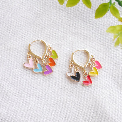 Colorful heart cluster hoop earrings on a white cloth.