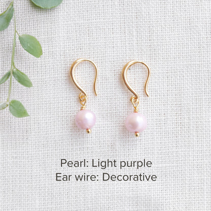A pair of baroque freshwater pearl earrings on a white cloth.