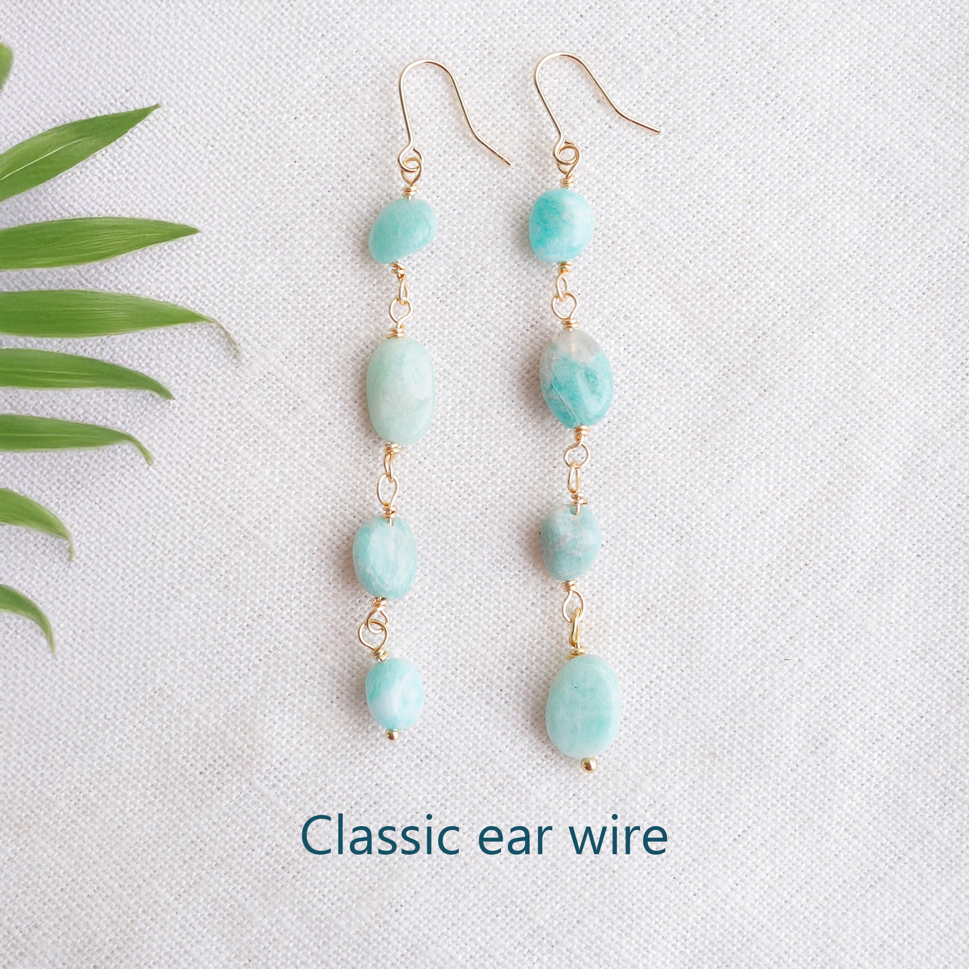 Amazonite gemstone long dangle earrings on a white cloth.