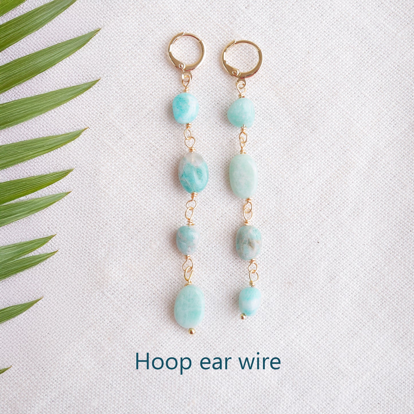 Amazonite gemstone long dangle earrings on a white cloth.