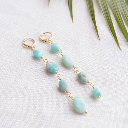 Amazonite gemstone long dangle earrings on a white cloth.