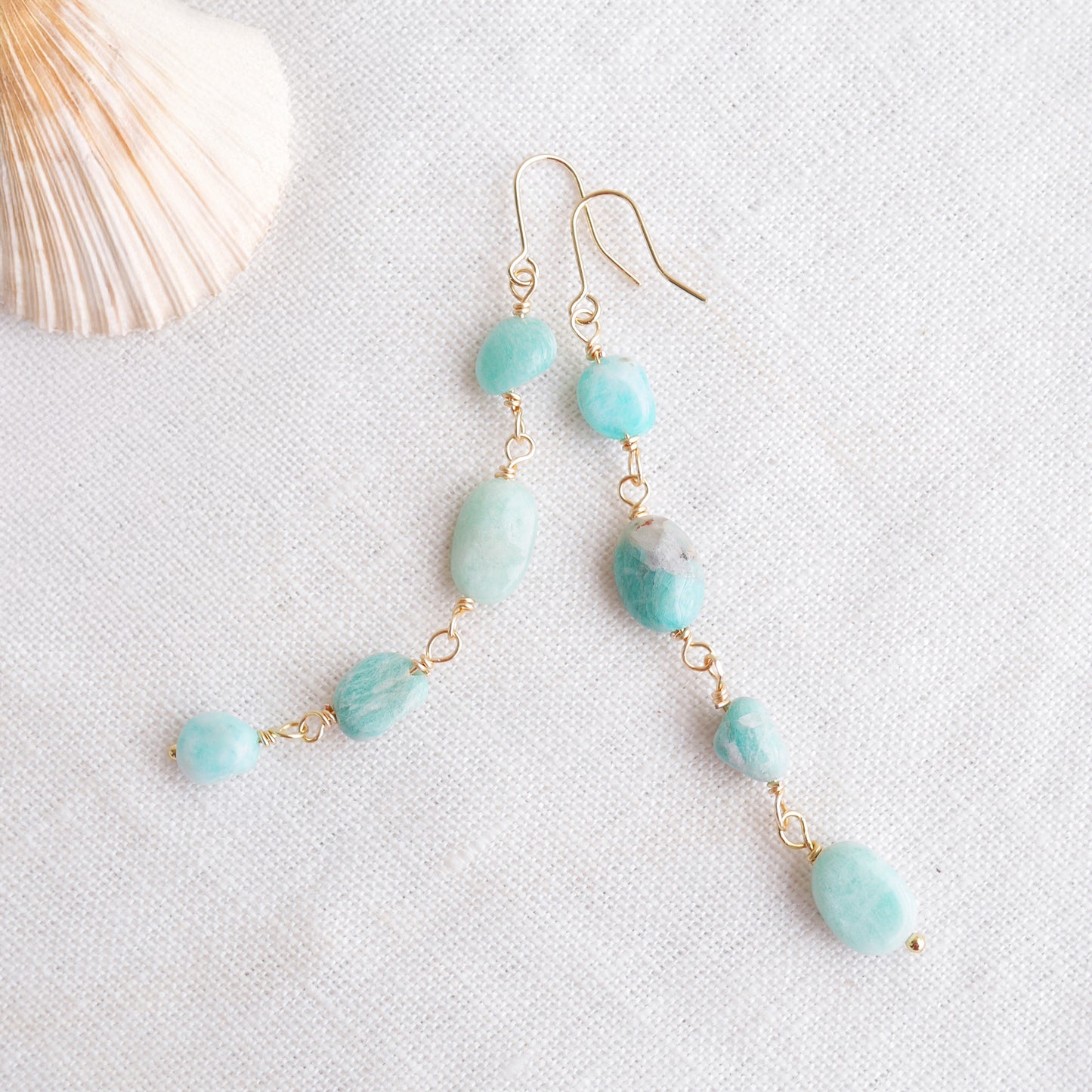 Amazonite gemstone long dangle earrings on a white cloth.