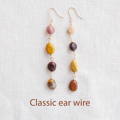 Long jasper stone dangle earrings in earthy mookaite colors, on a white cloth.