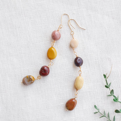 Long jasper stone dangle earrings in earthy mookaite colors, on a white cloth.