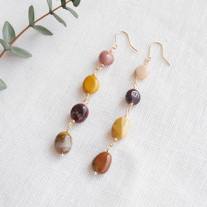 Long jasper stone dangle earrings in earthy mookaite colors, on a white cloth.