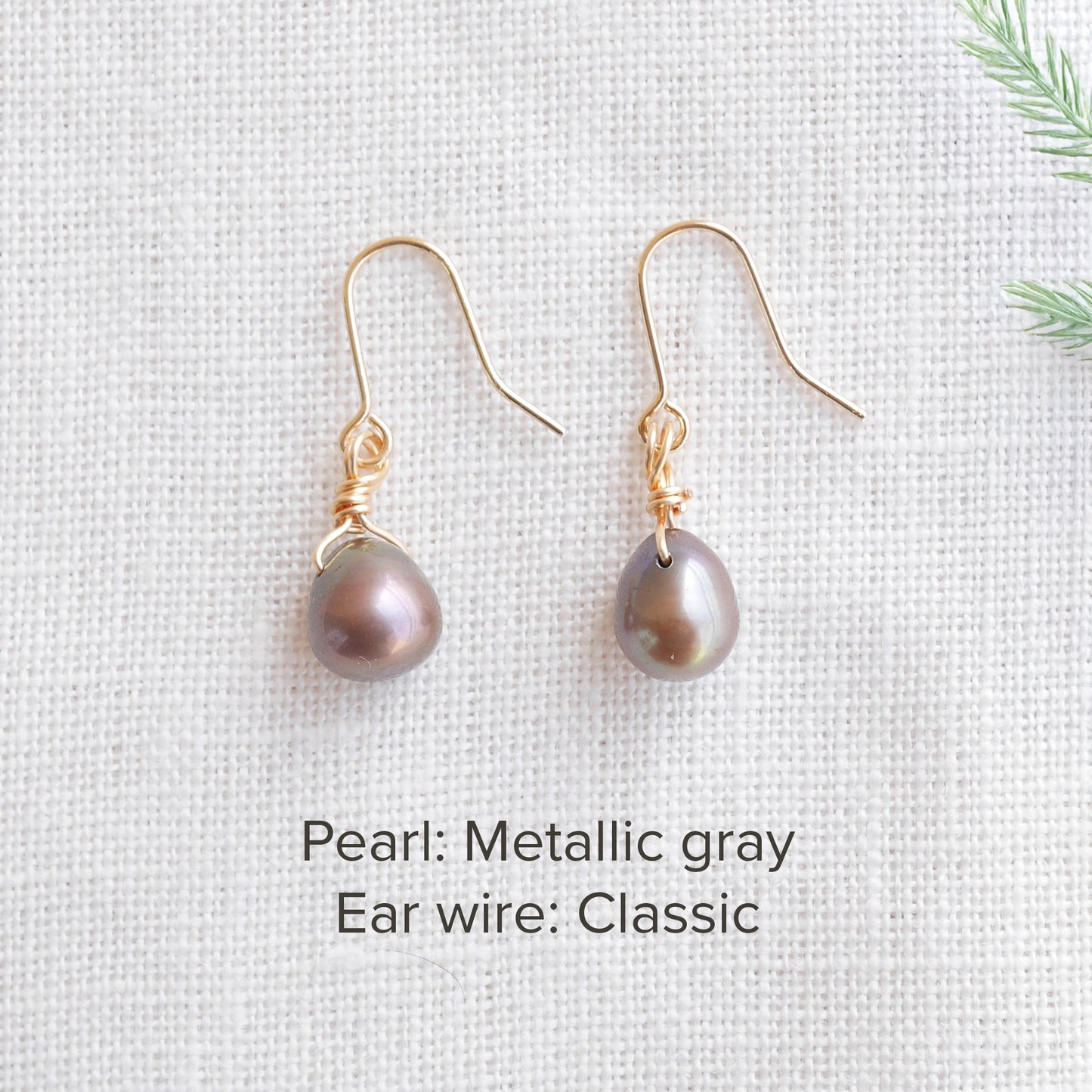A pair of baroque freshwater pearl earrings on a white cloth.