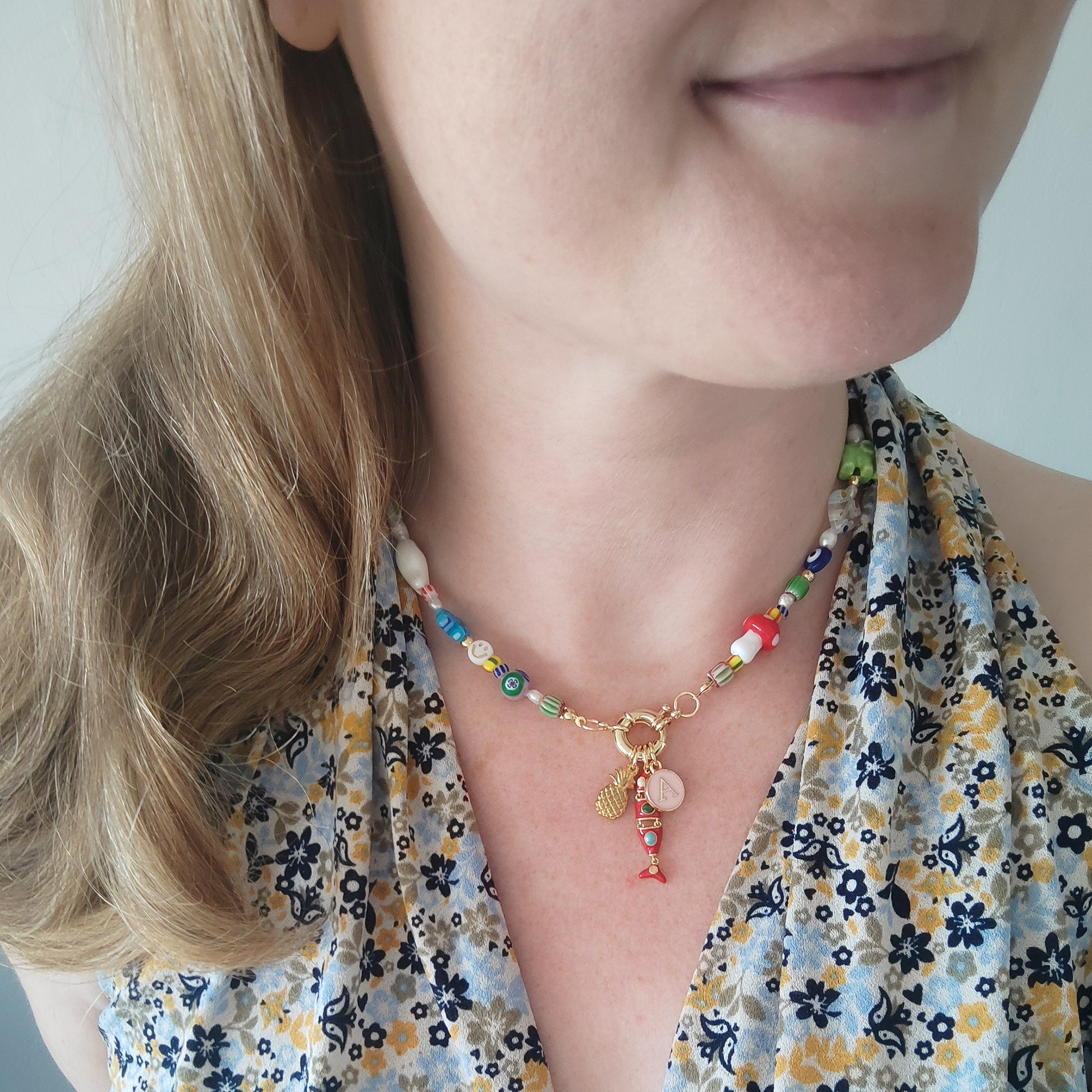Woman wearing a colorful mixed beads necklace with custom charms.