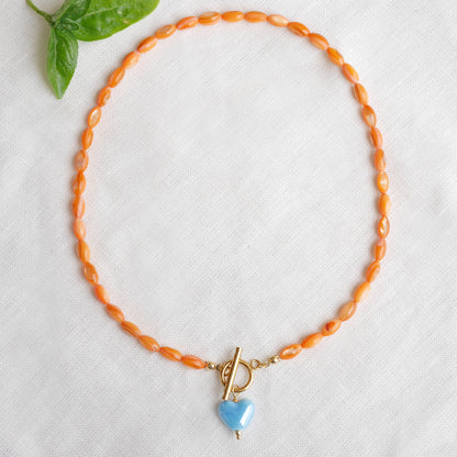 Orange beaded necklace - blue porcelain heart charm, toggle clasp