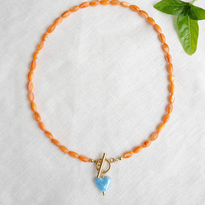 Orange beaded necklace - blue porcelain heart charm, toggle clasp