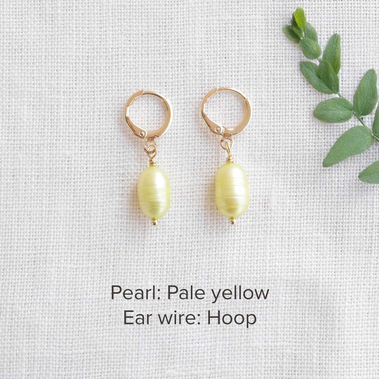 A pair of baroque freshwater pearl earrings on a white cloth.