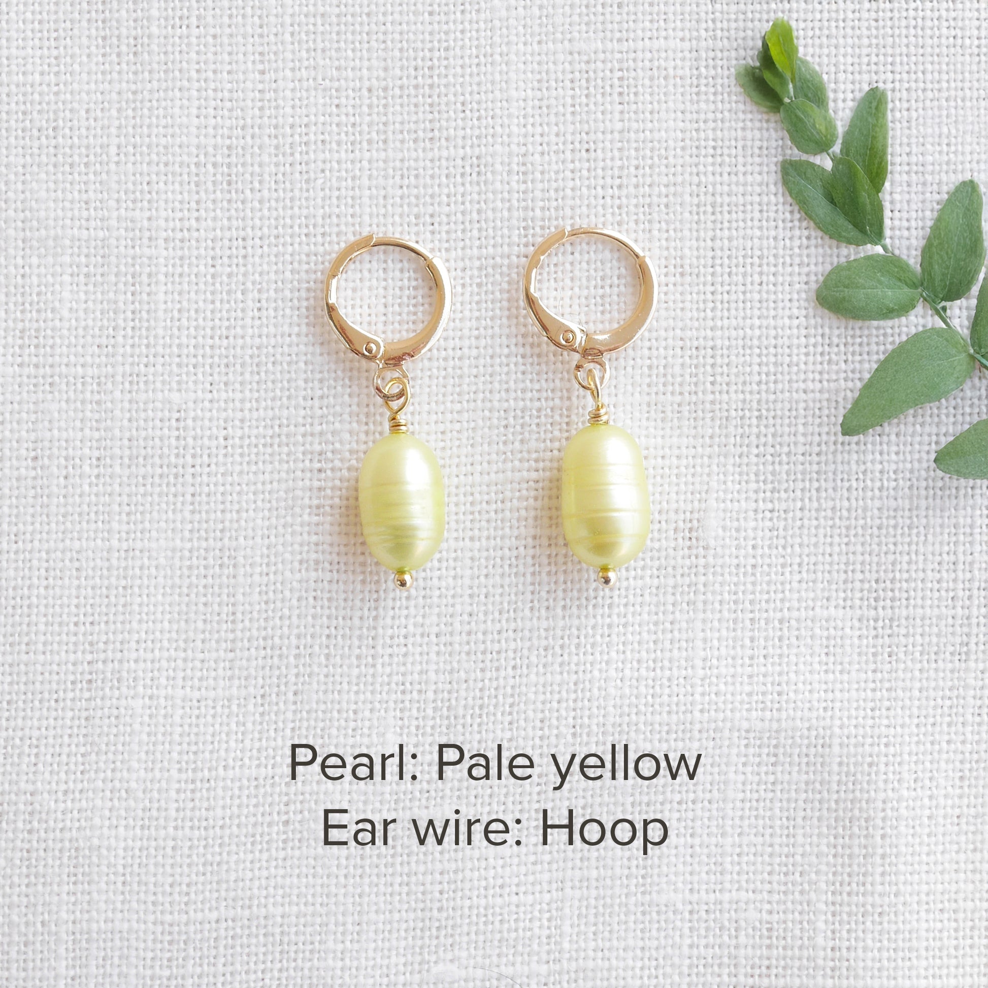 A pair of baroque freshwater pearl earrings on a white cloth.