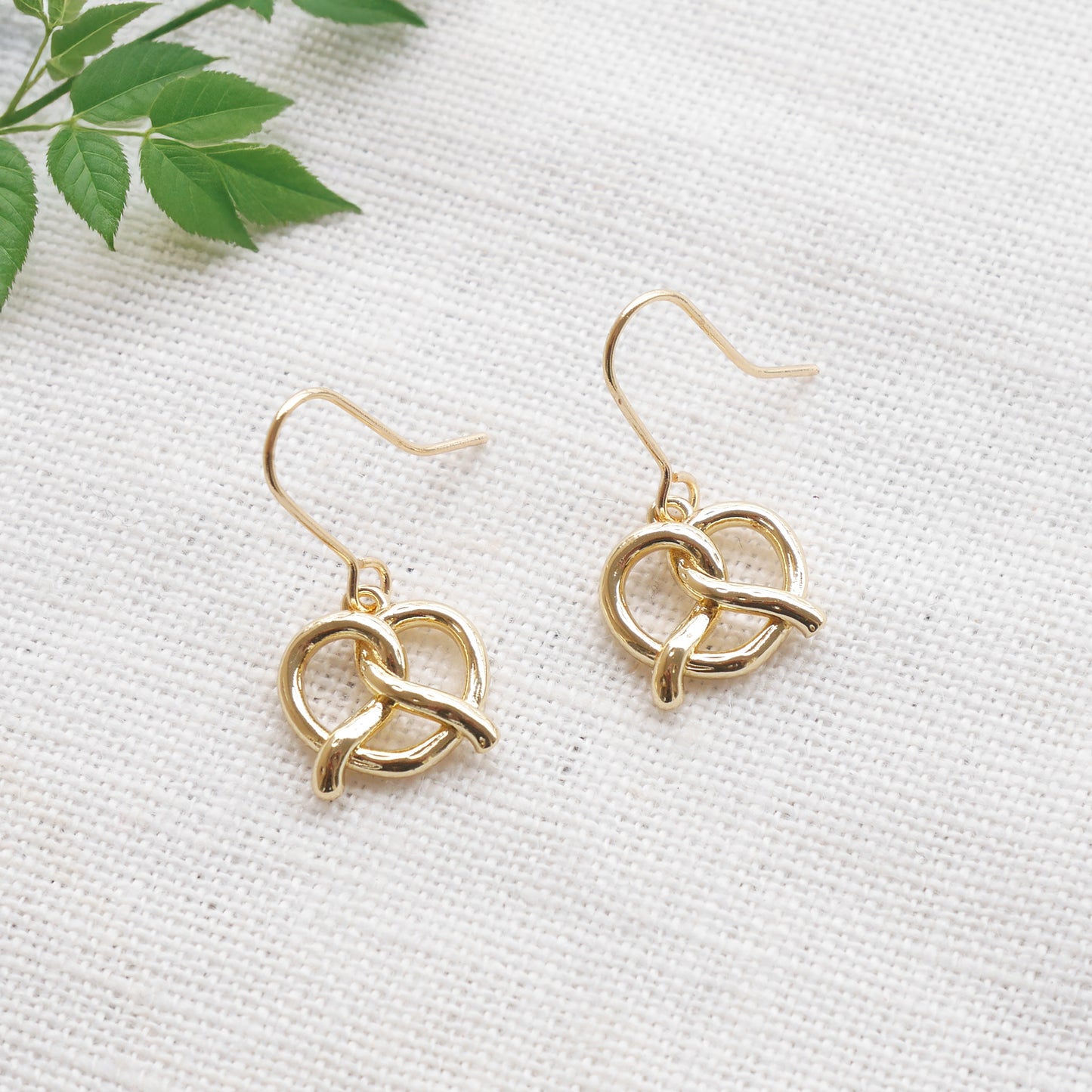 pretzel earrings on a white cloth.