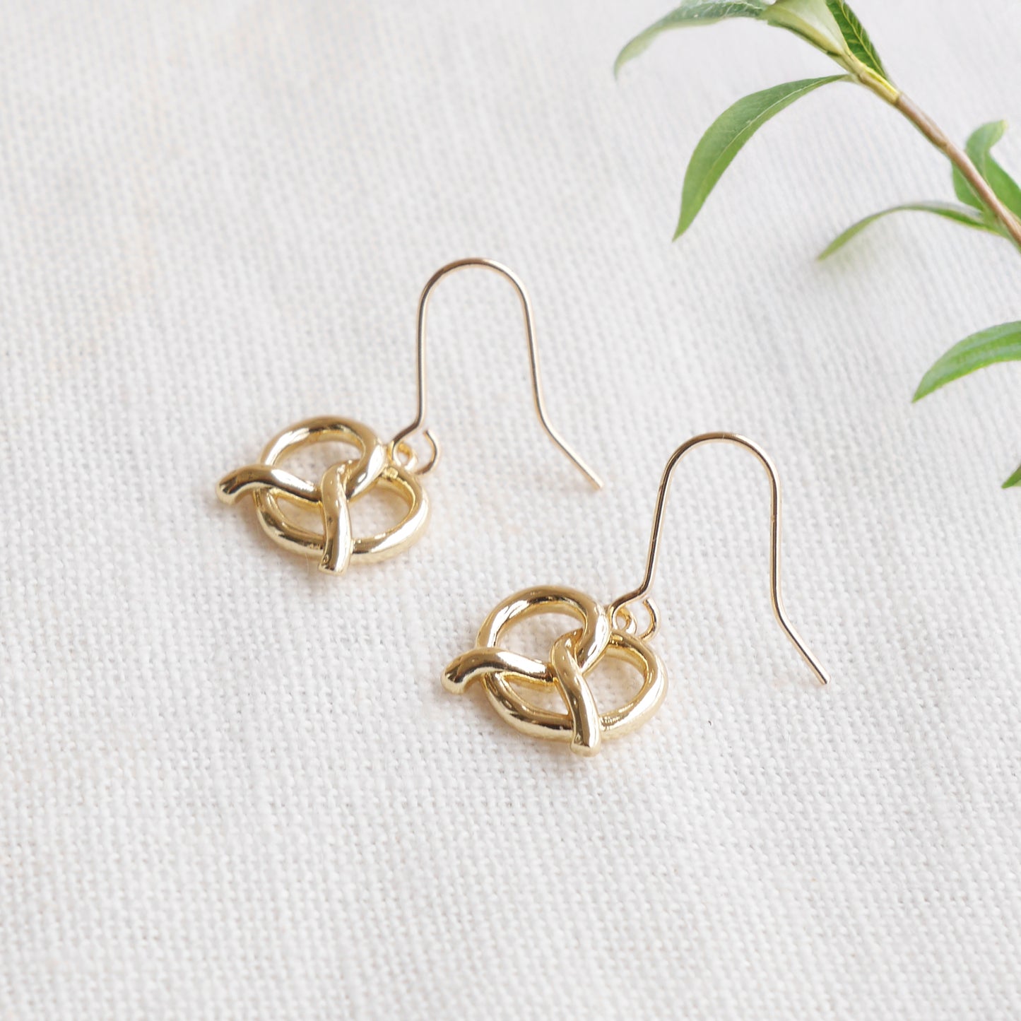 pretzel earrings on a white cloth.