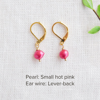 A pair of baroque freshwater pearl earrings on a white cloth.