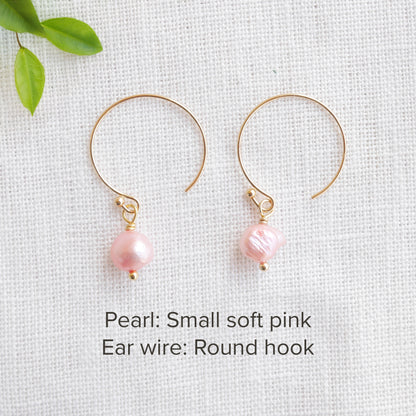A pair of baroque freshwater pearl earrings on a white cloth.